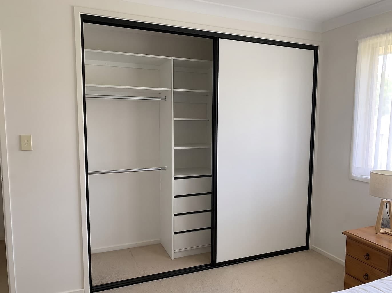 The same opening with new white sliding doors and a proper fitted interior of shelving and drawers
