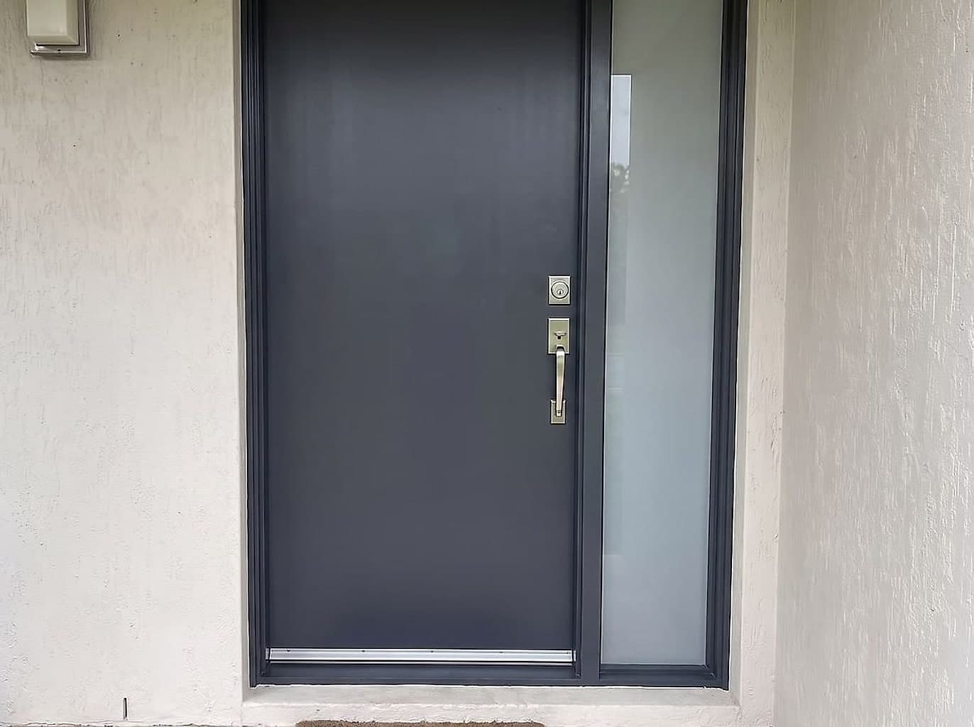 The same doorway with a new charcoal entry door and a matching handle and deadbolt