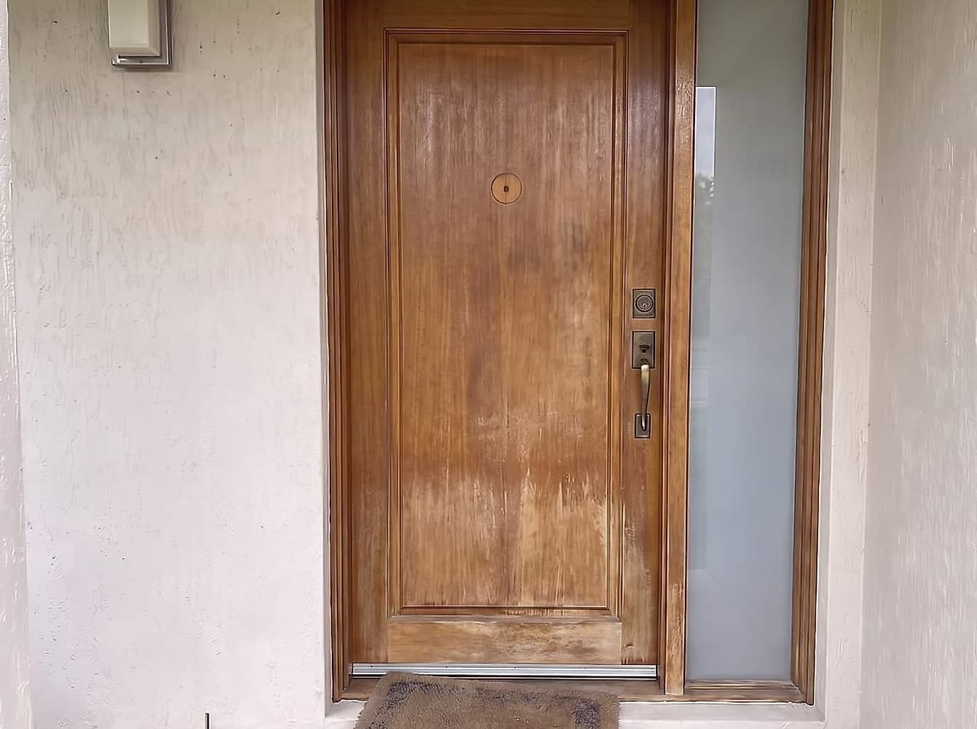 Front entry door with perished flaking varnish, water damage and tarnished mismatched hardware