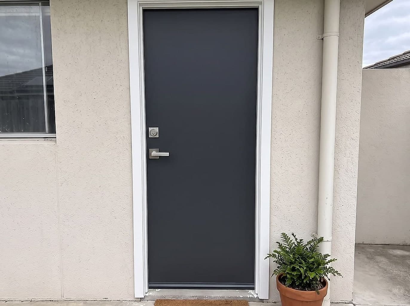 The same doorway with a new door hung square, a matching handle and deadbolt, and new weather seals
