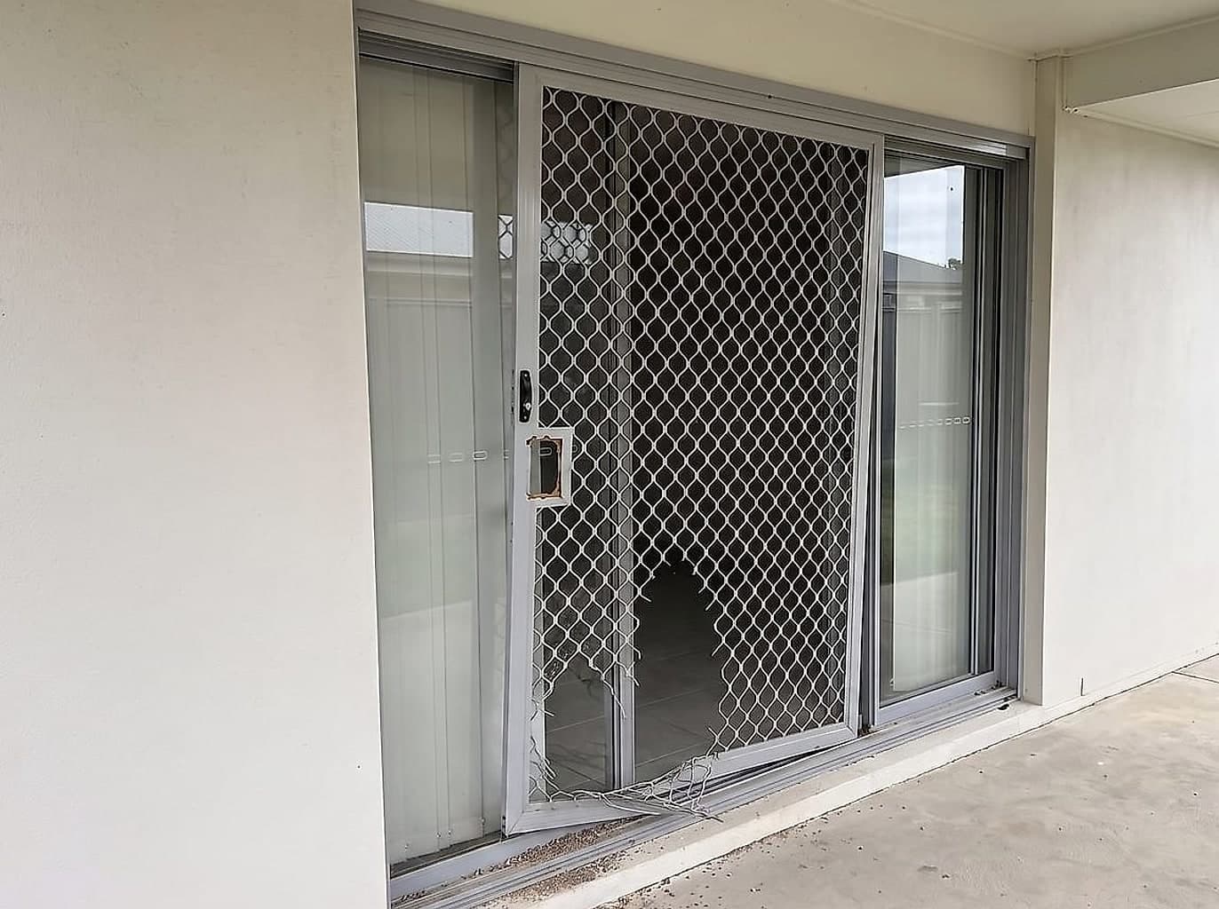 Security screen door off its track and jammed, the mesh ripped open and the lock missing