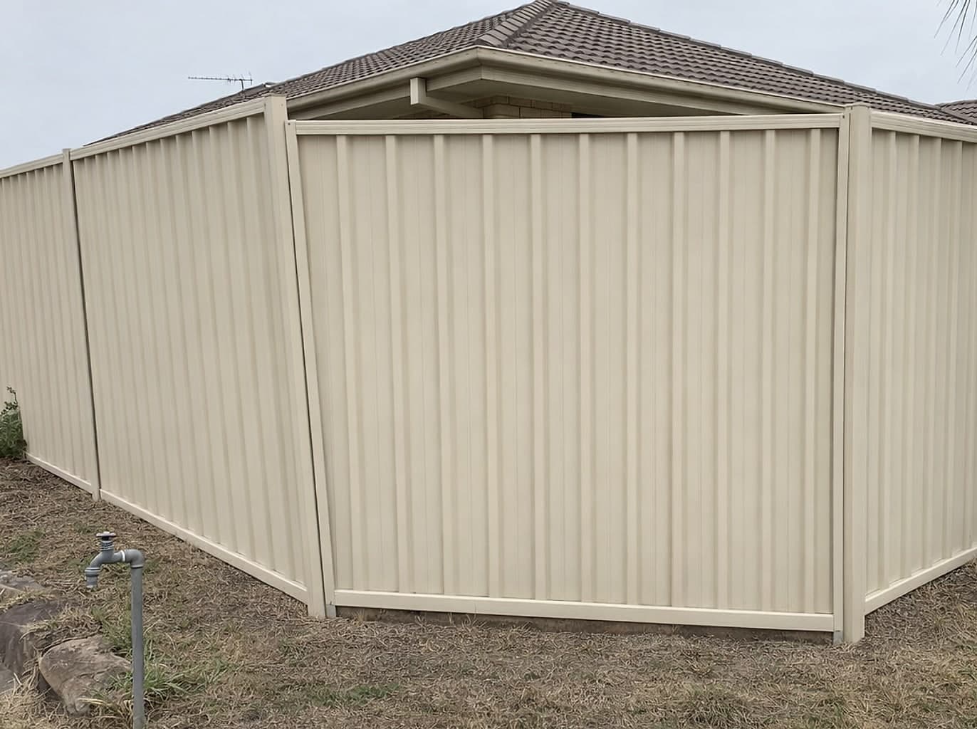The same boundary with a new charcoal colorbond fence standing straight and true