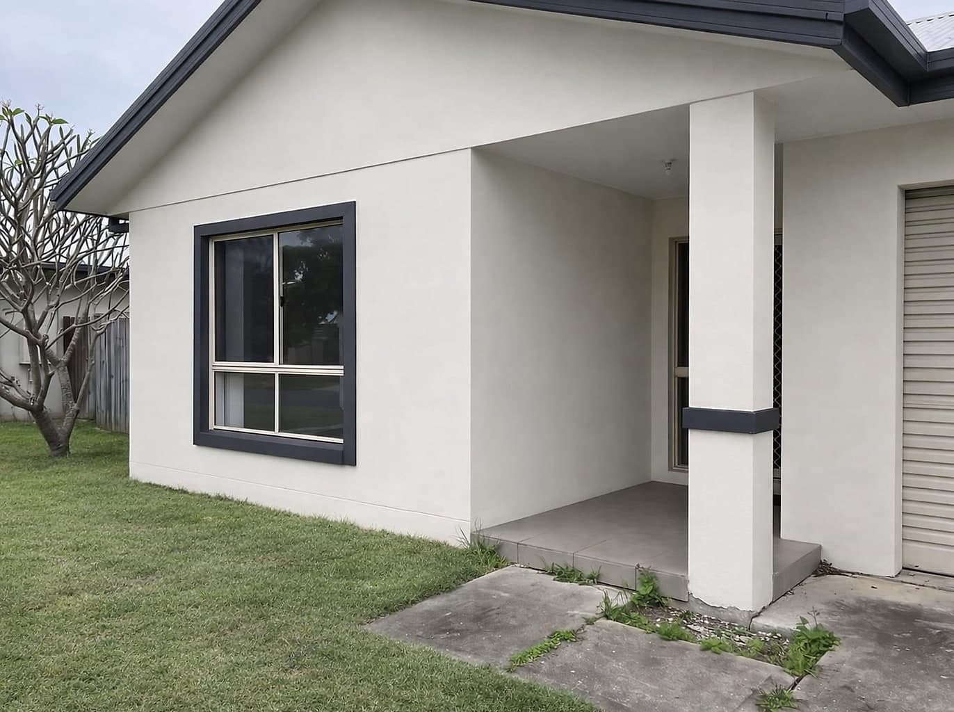 The same house repainted in a clean off-white with crisp charcoal trims