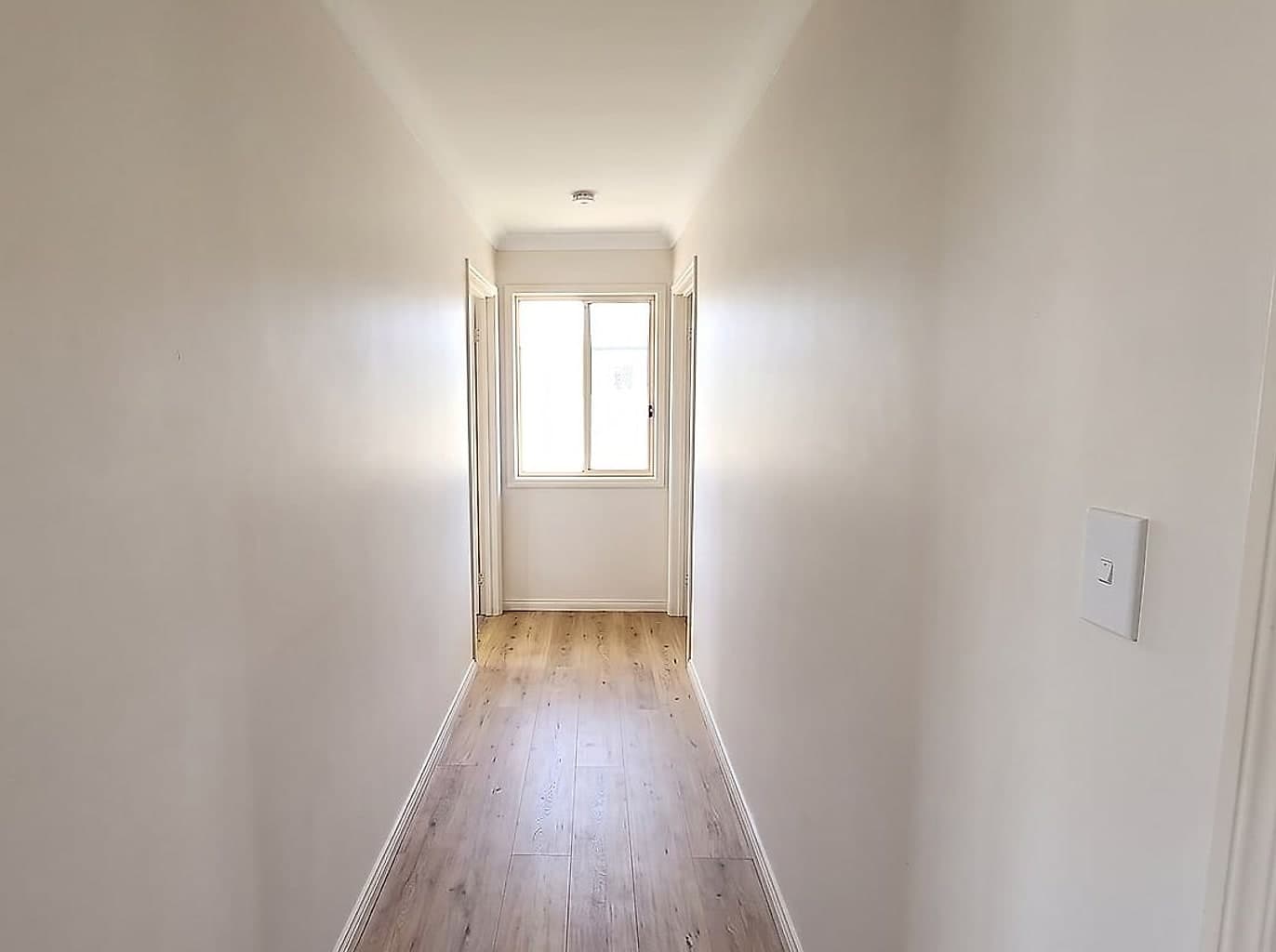 The same hallway with new cornice run, the crack filled flush and everything repainted
