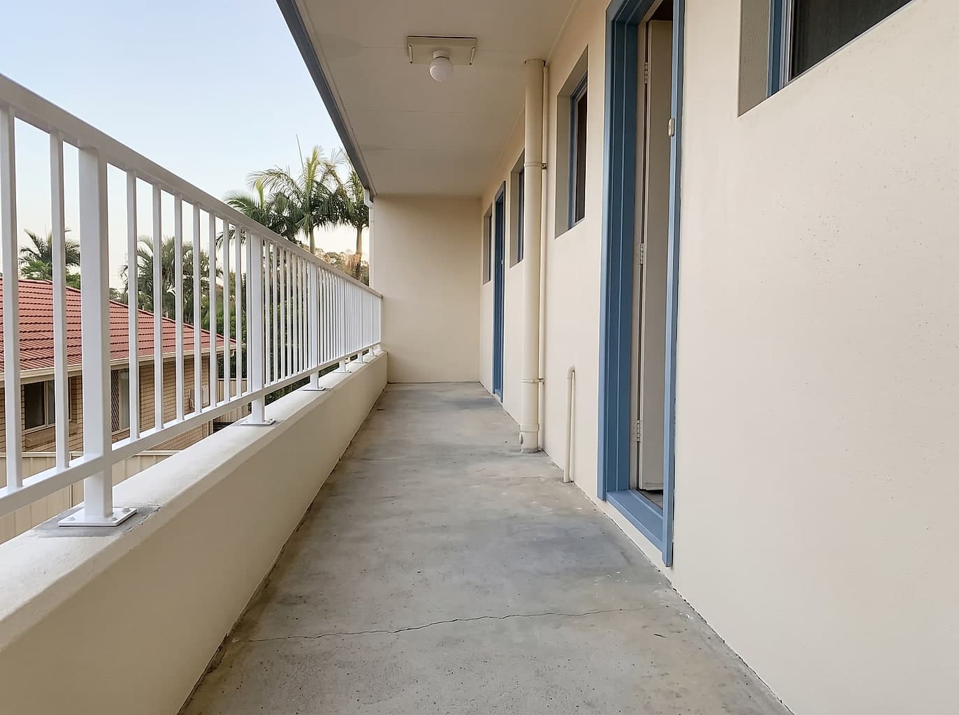 The same walkway repainted with a restored white balustrade and patched concrete