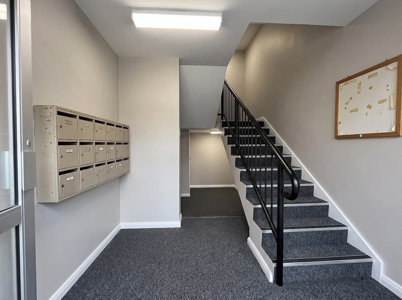 The same lobby repainted with new carpet, a resprayed handrail and better lighting